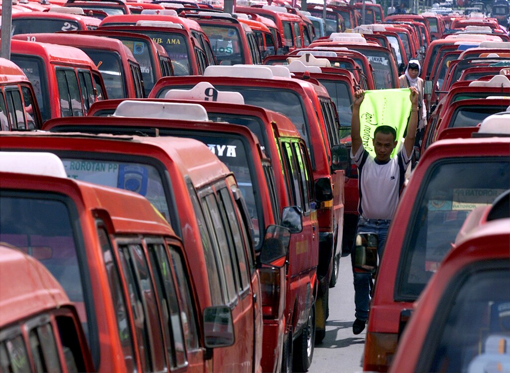 An Indonesian public transport driver walks between rows of parked mini-buses during a drivers' strike in front of the Jakarta provincial governor's office on January 25, 2001. Hundreds of drivers packed their vehicles in the inner city street to protest a 100 percent increase in the fee for tests for public transport drivers. Under pressure from the cash-strapped central government trying to plug its budget deficit, provincial administrations around the country are pushing up a range of such fees to boost revenues.EN/TJF/CP - RP2DRIGKTJAA