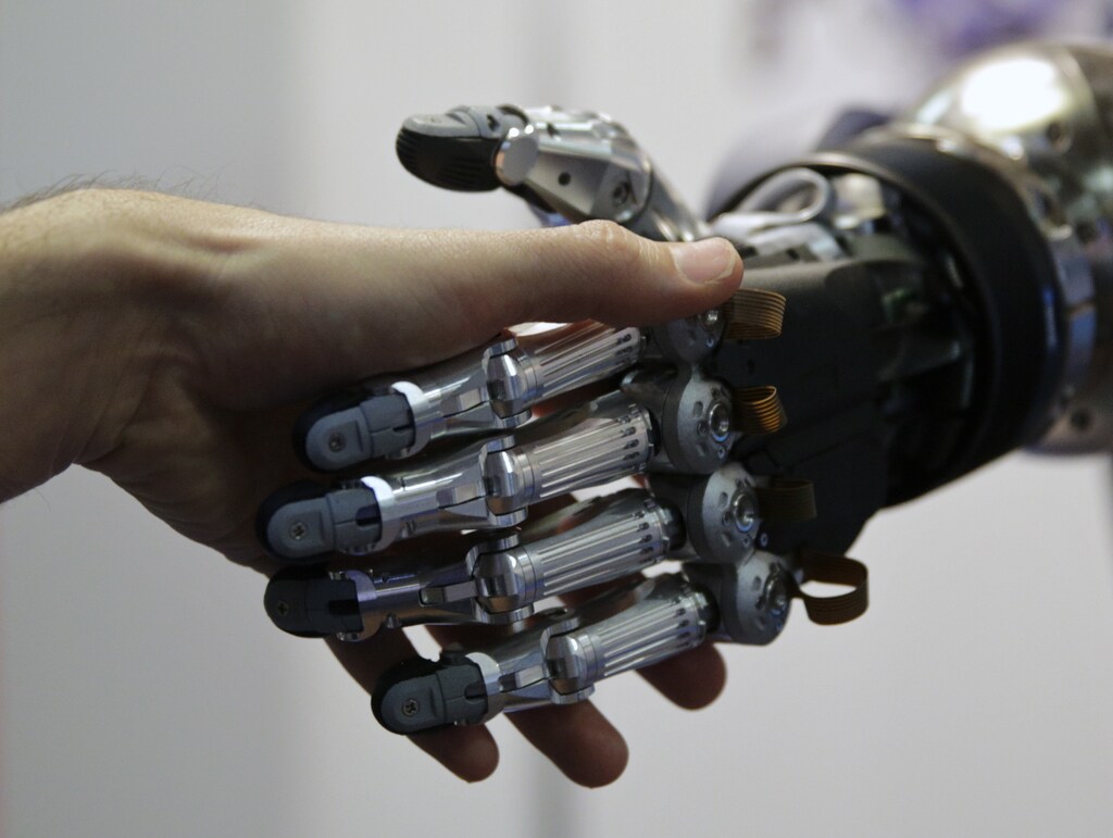A man shakes hands with a humanoid robot during the International Conference on Humanoid Robots in Madrid November 19, 2014. REUTERS/Andrea Comas (SPAIN - Tags: SCIENCE TECHNOLOGY) - GM1EABJ1TGT01
