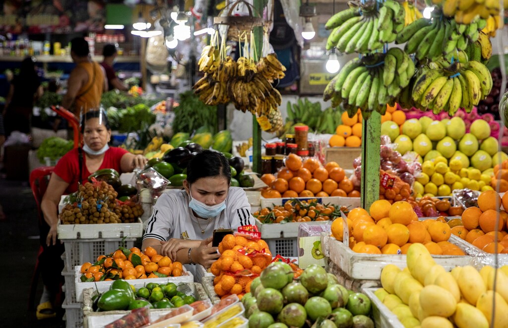 a picture of fruit sellers surrounded by different coloured fruits