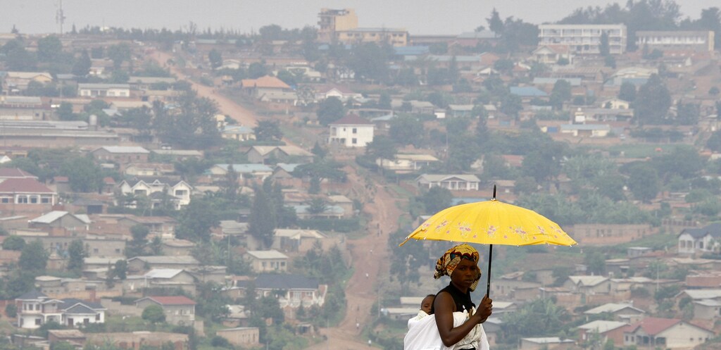 A woman watches the arrival of German President Horst Koehler on a main street of Rwanda's capital Kigali February 6, 2008. Koehler is on a three-day visit to Rwanda.