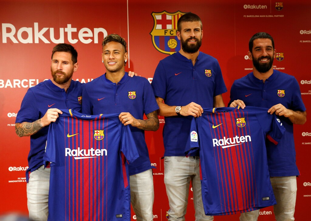 FC Barcelona players (L-R) Lionel Messi , Neymar, Gerard Pique and Arda Turan holding their uniforms pose for a photo during a news conference to announce the sponsorship deal between the team and Japanese e-commerce operator Rakuten Inc. in Tokyo, Japan July 13, 2017. REUTERS/Kim Kyung-Hoon - RC1F6F314C70