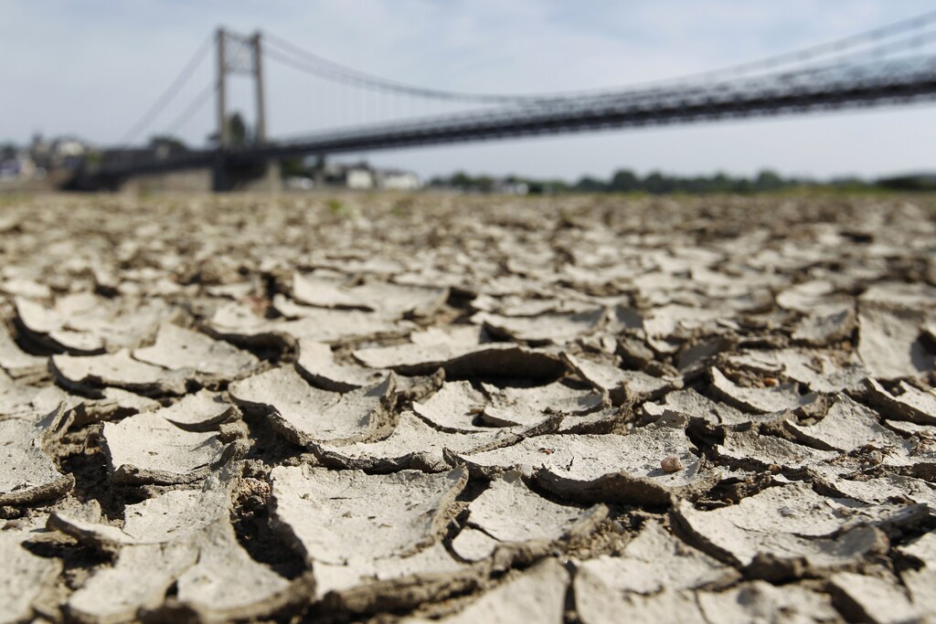 Cracked and dry earth is seen in the wide riverbed of the Loire River near the Anjou-Bretagne bridge in Ancenis, western France, May 20, 2011. The French environment minister said on Monday that France was in a 'situation of crisis' and on Wednesday imposed curbs on water consumption in a third of France's administrative departments. REUTERS/Stephane Mahe (FRANCE - Tags: ENVIRONMENT) - PM1E75K0X8B01