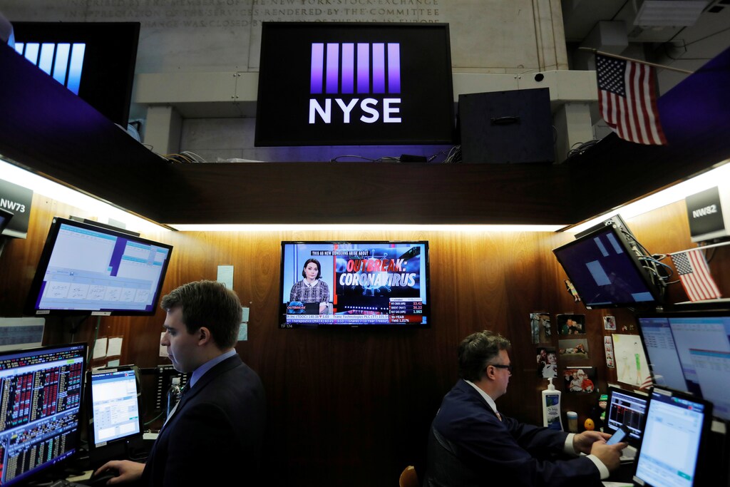 Coronavirus updates are seen on a news broadcast as traders work on the floor of the New York Stock Exchange (NYSE) in New York City, New York, U.S., March 11, 2020. REUTERS/Andrew Kelly - RC2RHF9B7F0Y