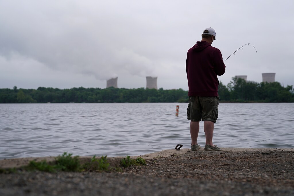 A man fishes in the Susquehanna River in front of the Three Mile Island Nuclear power plant in Goldsboro, Pennsylvania, U.S. May 30, 2017. REUTERS/Carlo Allegri - RC1670FDEB70