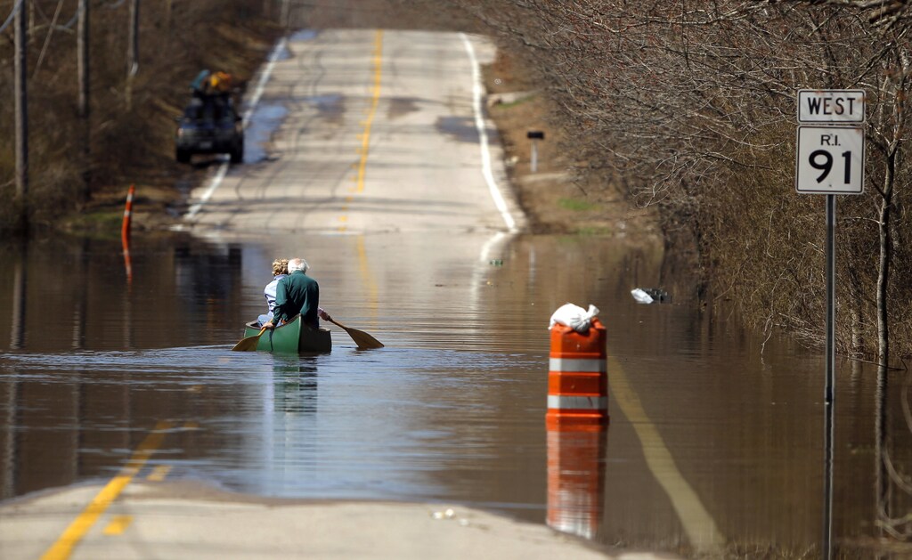 A couple canoes across a flooded section of road in Westerly, Rhode Island April 1, 2010. REUTERS/Brian Snyder (UNITED STATES - Tags: ENVIRONMENT TRANSPORT IMAGES OF THE DAY SOCIETY) - GM1E642036W01