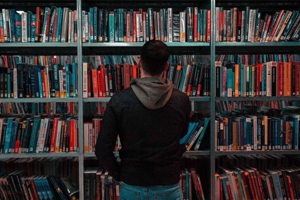A person standing in front of library bookshelves.