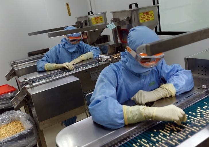 Employees inspect tablets as they move along the production line at a pharmaceutical plant of Lupin, India's No. 2 drugmaker, in Verna, in the western state of Goa, India, June 9, 2017. Picture taken June 9, 2017. REUTERS/Danish Siddiqui