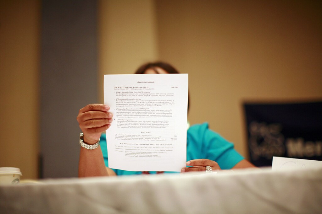 A woman looks over a resume during a job fair in New York June 11, 2012. REUTERS/Eric Thayer (UNITED STATES - Tags: BUSINESS EMPLOYMENT) - RTR33GEM
