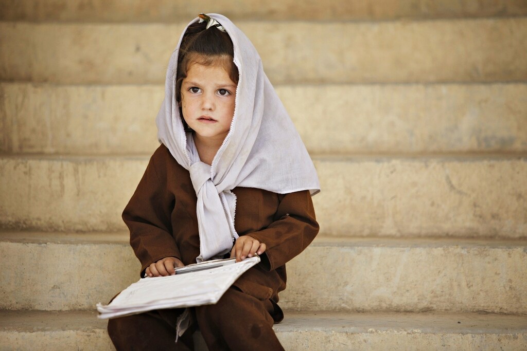 A schoolgirl sits on the steps outside her classroom at Syed Pasha school, built by Canadian troops, near Kandahar Air Field September 8, 2009. REUTERS/Finbarr O'Reilly (AFGHANISTAN CONFLICT POLITICS EDUCATION) - RTR27KEI