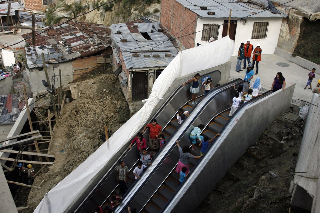 People travel on an outdoor public escalator at Commune 13 in Medellin January 12, 2012. A huge 384 metres (1,260 ft) long outdoor escalator, divided into six sections, has been erected in one of the poorest districts of Colombia's second largest city to help the 12,000 residents there get around. REUTERS/Fredy Builes (COLOMBIA - Tags: SOCIETY POVERTY TPX IMAGES OF THE DAY) - RTR2W6VK