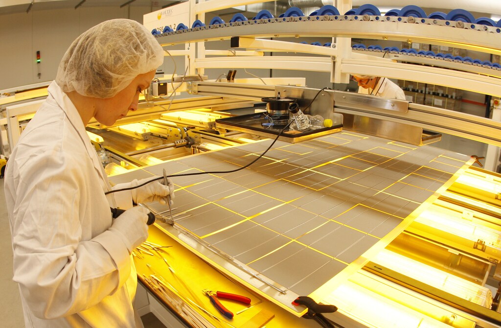 Employees work at the assembly line of photovoltaic panels at the Voltec Solar factory in Dinsheim sur Bruche near Strasbourg, March 11, 2010. REUTERS/Vincent Kessler (FRANCE - Tags: BUSINESS ENERGY ENVIRONMENT) - PM1E63B15AI01