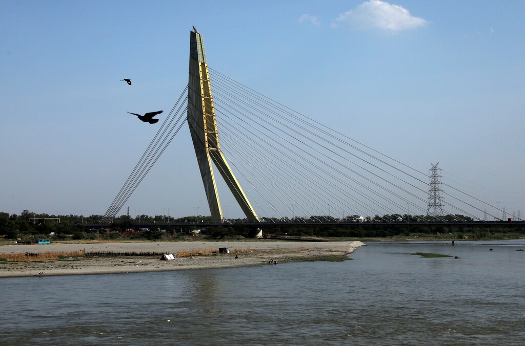 Birds fly over the waters of the Yamuna river near the Signature bridge, after air pollution level started to drop during a nationwide lockdown to slow the spreading of the coronavirus disease (COVID-19), on Earth Day in New Delhi, India, April 22, 2020. REUTERS/Anushree Fadnavis - RC2O9G9SOW20