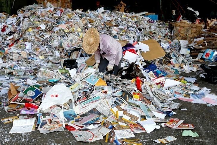 A worker picks rubbish from waste paper to be shipped to mainland China at a factory in Hong Kong, China September 19, 2017. Picture taken September 19, 2017. REUTERS/Bobby Yip