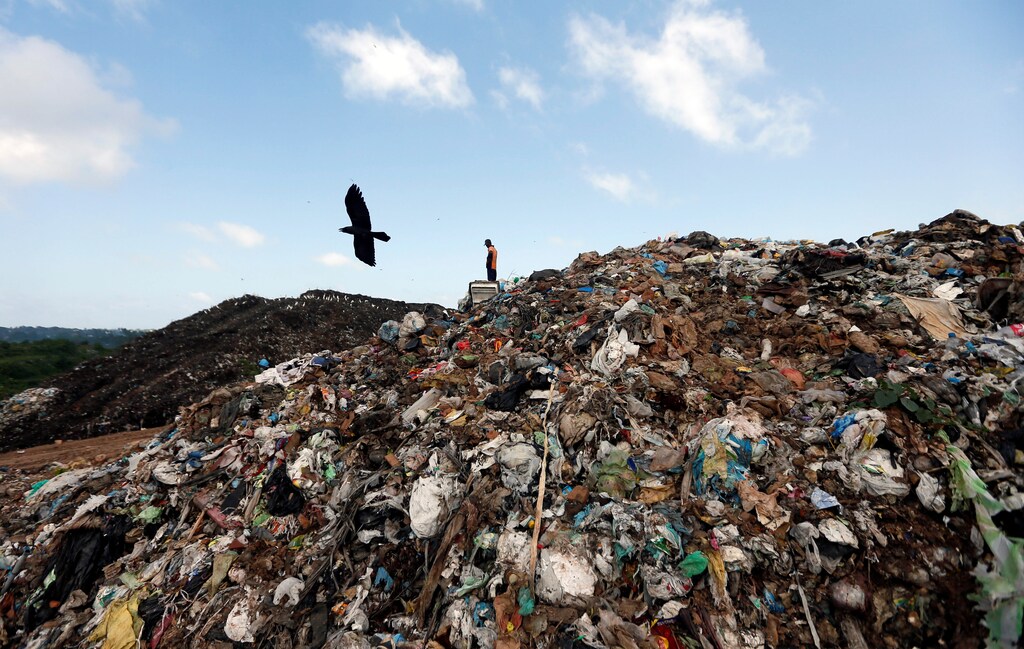 A man collects plastic for recycling in a garbage dump in Colombo, Sri Lanka June 9, 2017. REUTERS/Dinuka Liyanawatte - RTX39S9J