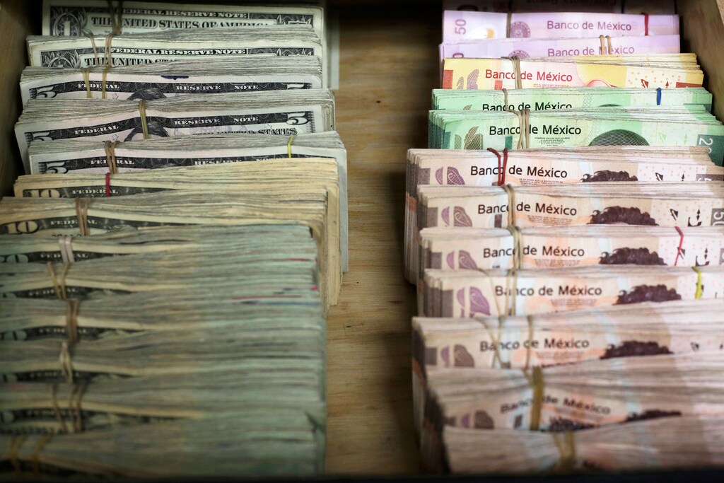 Bundles of banknotes of Mexican Peso and U.S. Dollar are pictured at a currency exchange shop in Ciudad Juarez, Mexico January 15, 2018. REUTERS/Jose Luis Gonzalez - RC1F0969F510