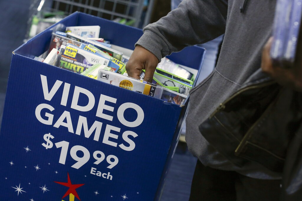 A shopper reaches in a discounted video game bin at a Best Buy store in Westbury, New York November 28, 2014. The Best Buy re-opened at 8am after opening Thanksgiving evening at 5pm and closing at 10 pm ahead of many other Black Friday retailers.REUTERS/Shannon Stapleton (UNITED STATES - Tags: BUSINESS) - GM1EABT00S401