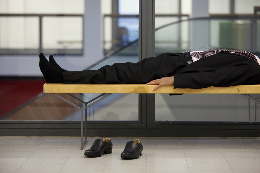 A man sleeps on a bench at the Internationale Gruene Woche IGW (International Green Week) agriculture and food fair on its opening day in Berlin, January 21, 2011. The annual exhibition of food stuffs and agricultural products is one of the world's largest of its kind. It opened its doors on Friday for the 76th time. REUTERS/Thomas Peter (GERMANY - Tags: AGRICULTURE FOOD SOCIETY) - BM2E71L1BU501