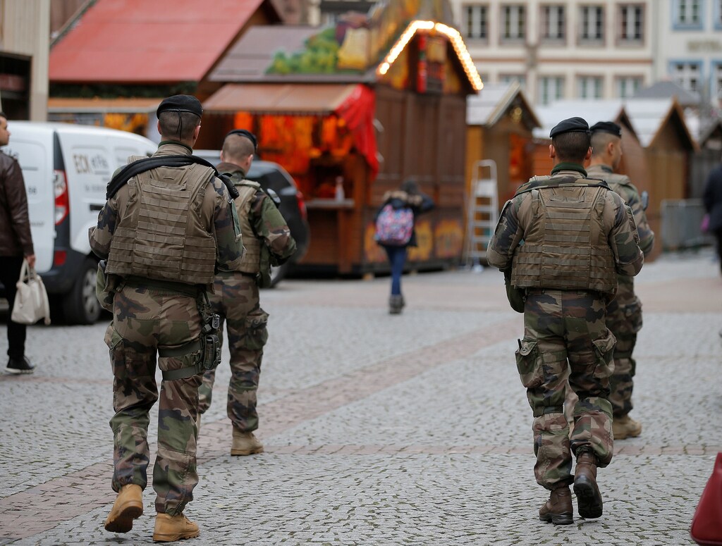 French soldiers patrol past wooden barracks shops during the installation of the traditional Christkindelsmaerik (Christ Child market) near Strasbourg's cathedral in Strasbourg, France, November 21, 2016. France said on Monday it had foiled a terrorist plot and arrested seven people, a year after a state of emergency was imposed to counter a wave of Islamist attacks. REUTERS/Vincent Kessler - RTSSNH1