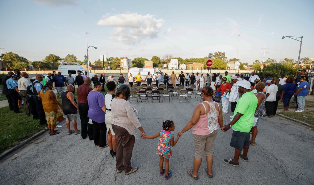 Chicago police officers and community members gather in a prayer during 'Operation Wake-Up' rally supporting efforts to help stop the violence in the city, July 2017.