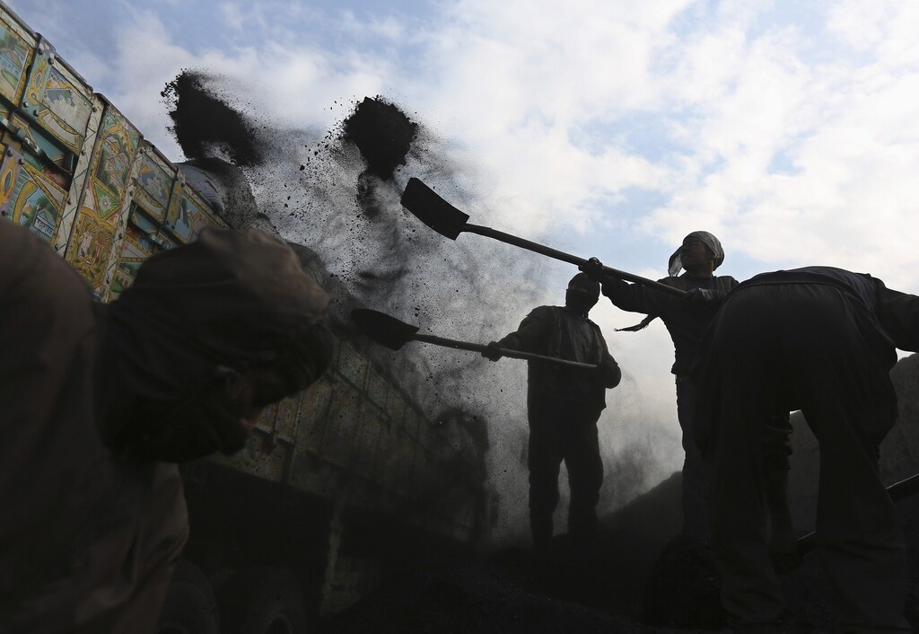 Labourers shovel coal onto a truck at a coal dump site outside Kabul January 23, 2014.