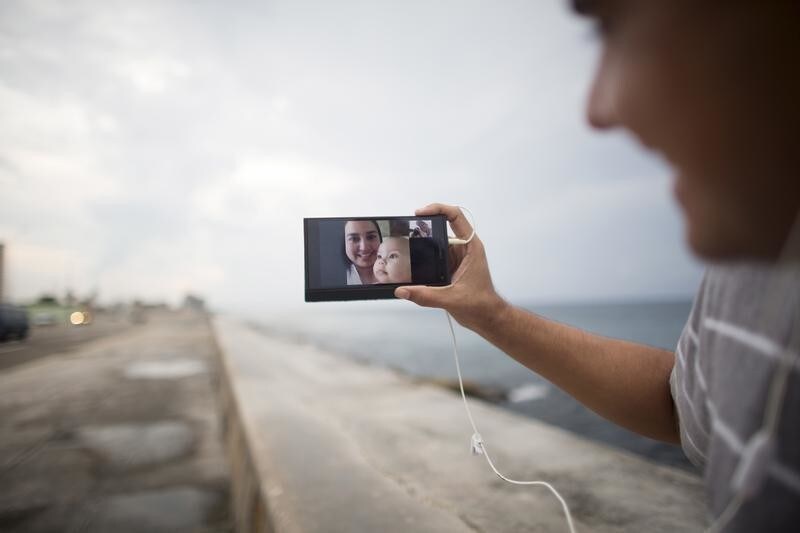 Artist Dariel Llerandis, 31, shows his wife and his 6 month old daughter who live in Miami as he speaks to them using the internet at a Wi-Fi hotspot in Havana, September 22, 2015.