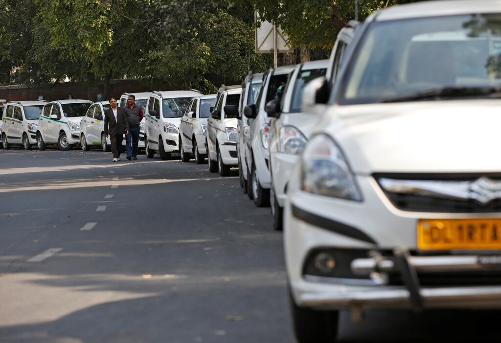 Drivers of Uber and Ola walk next to their parked vehicle's during a protest in New Delhi, India, February 14, 2017. REUTERS/Adnan Abidi - RTSYKRO