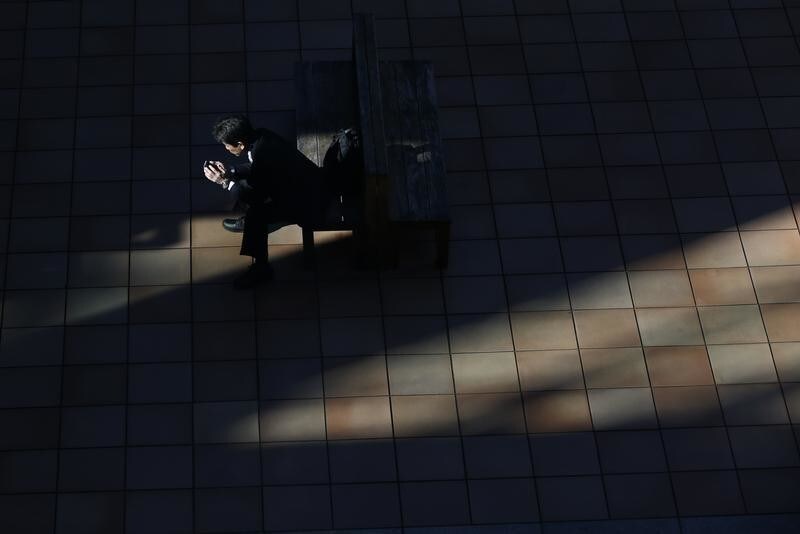 A man uses a smartphone on a street in Tokyo November 21, 2013. The Bank of Japan maintained its ultra-loose monetary policy on Thursday and reiterated the economy is recovering moderately, in a nod to signs of a pick-up in exports that is key to sustaining the momentum generated by premier Shinzo Abe's stimulus. REUTERS/Issei Kato (JAPAN - Tags: BUSINESS EMPLOYMENT TELECOMS TPX IMAGES OF THE DAY) - RTX15MMY