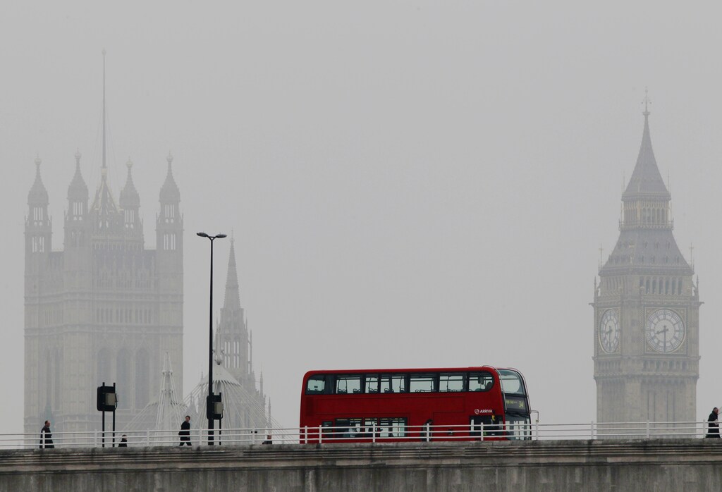 A bus crosses Waterloo bridge in front of the Houses of Parliament during a misty morning in London April 13, 2012. REUTERS/Luke MacGregor (BRITAIN - Tags: CITYSPACE POLITICS TRANSPORT ENVIRONMENT) - RTR30O79