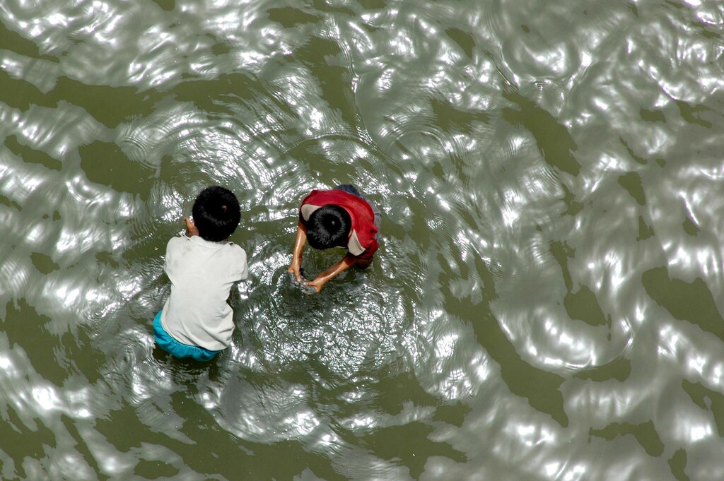 Indian boys search for coins thrown into the River Ganges by Hindu devotees in Patna, capital of the Indian state of Bihar,.