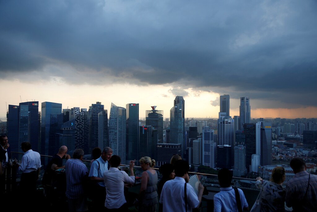 Tourists have drinks at a hotel rooftop bar as clouds gather over the central business district in Singapore June 6, 2016. REUTERS/Edgar Su/Files - RTX2TP10