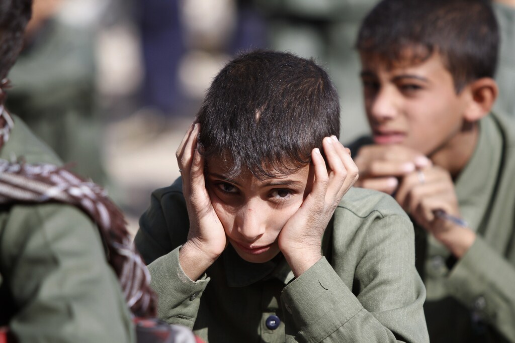 Students listen to their teacher during class outside their school compound that was taken over by Shi'ite Houthi rebels, who had moved armoured vehicles into the compound, during recent fighting with government forces in Sanaa September 29, 2014. REUTERS/Mohamed al-Sayaghi