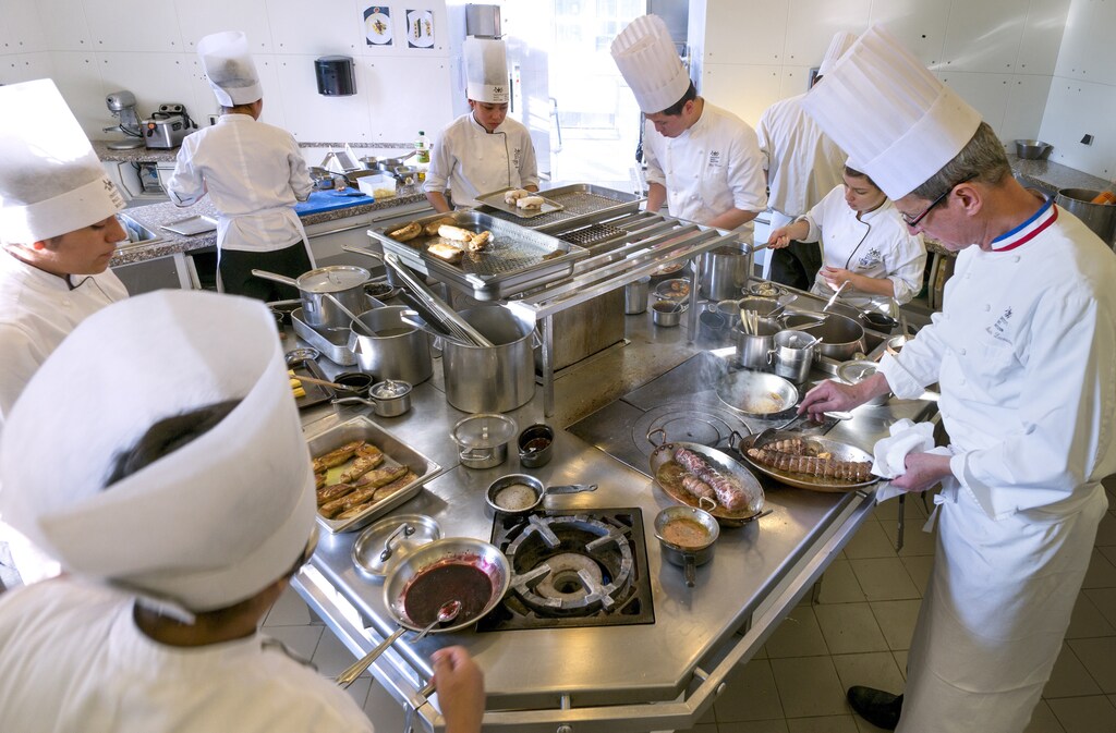 Students work in the kitchen of the teaching restaurant managed by French chef Alain Lecossec.