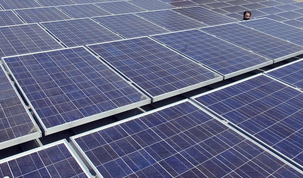 A man views solar panels on a roof at Google headquarters in Mountain View, California, June 18, 2007. Google announced today that they have switched on a solar panel installation at its headquarters which will help reduce the company's carbon footprint. REUTERS/Kimberly White (UNITED STATES) - GM1DVNATWEAA