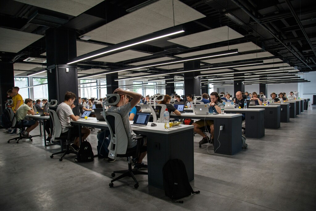 People working at desks in a large open-plan office, reflecting how technology, jobs and the evolving labour market are reshaping modern workplaces.