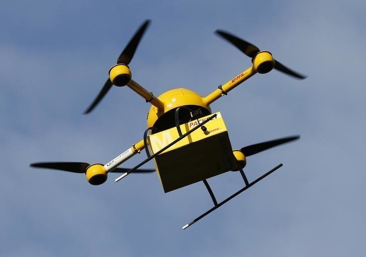A prototype "parcelcopter" of German postal and logistics group Deutsche Post DHL flies at 100m above ground, its maximum approved height, in Bonn December 9, 2013. DHL on Monday showed its prototype "parcelcopter," which is a modified microdrone that costs 40,000 euros ($54,900) and can carry packages up to 1.2 kg (2.65 pounds). REUTERS/Wolfgang Rattay (GERMANY - Tags: TRANSPORT SCIENCE TECHNOLOGY BUSINESS)