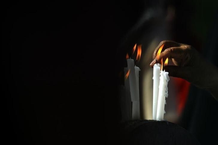 A Sri Lankan man lights a candle in memory of the tsunami victims during an all-religion prayer session in Colombo January 26, 2005. The tsunami struck exactly a month ago. REUTERS/Arko Datta AD/SH