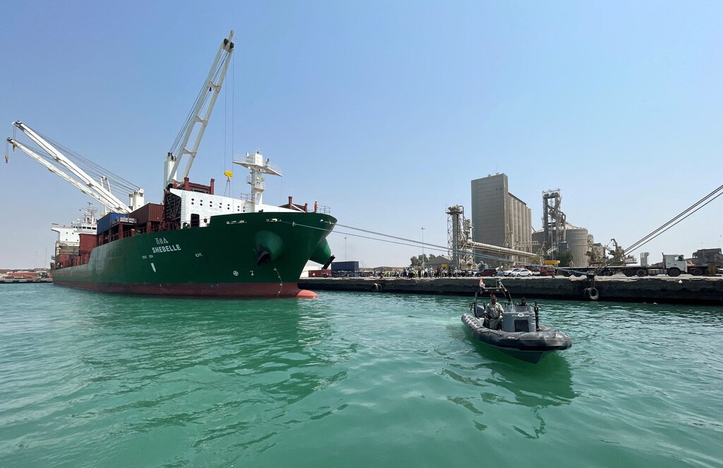 A coastguard boat sails past a commercial container ship docked at the Houthi-held Red Sea port of Hodeidah, as a container ship carrying general commercial goods docked at the port for the first time since at least 2016, in Hodeidah, Yemen February 25, 2023. REUTERS/Khaled Abdullah. geopolitical