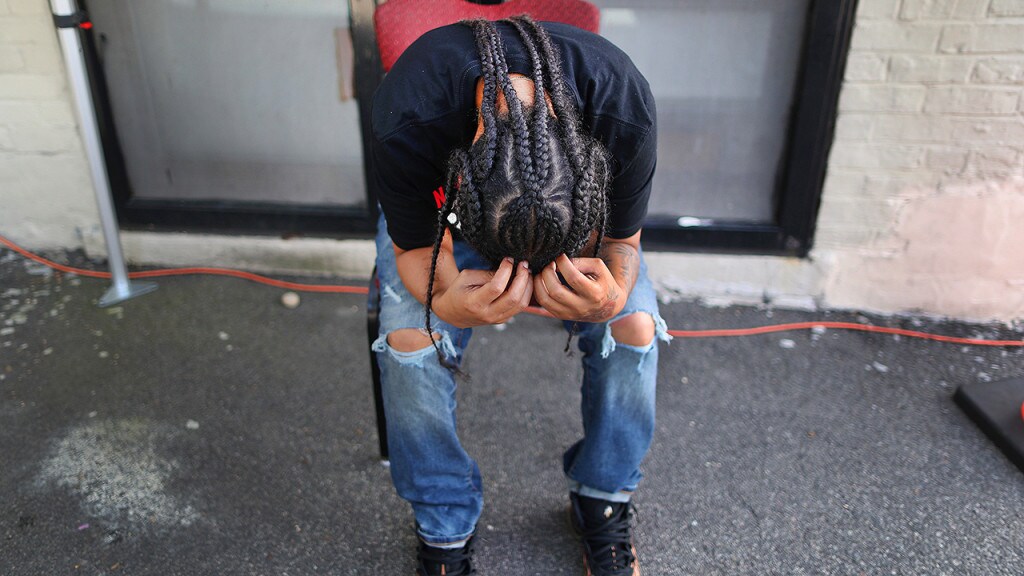 A person bows her head in her hands as she became apprehensive and nervous about being tested for COVID-19