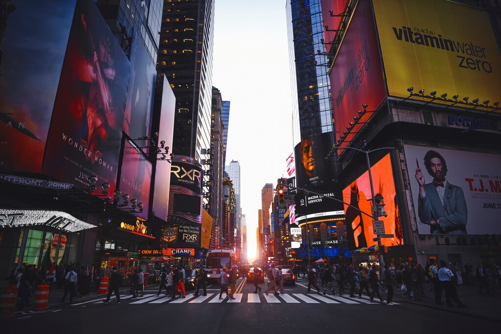 The image shows Times Square full of advertising hoardings to illustrate how advertising has the power to persuade people to adopt low-carbon lifestyles