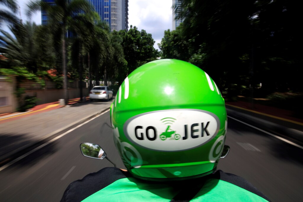 A Go-Jek driver rides a motorcycle on a street in Jakarta, Indonesia, December 15, 2017. REUTERS/Beawiharta - RC14B409FEA0