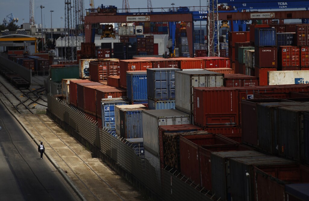 A man walks near containers at a port in Lisbon August 14, 2012. Portuguese port workers started a midnight strike against the revision of the legal framework for dock work. REUTERS/Rafael Marchante (PORTUGAL - Tags: BUSINESS EMPLOYMENT MARITIME CIVIL UNREST TPX IMAGES OF THE DAY) - GM2E88F00EP01