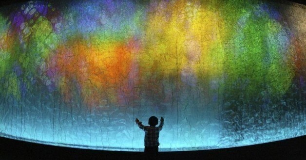 A boy touches a 45-metre (148-feet) long wall lighted by colour rays at an exhibition hall in Wuhan, central China's Hubei province May 1, 2007. Picture taken May 1, 2007. REUTERS/China Daily (CHINA) CHINA OUT