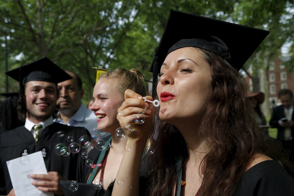 Graduating senior blows bubbles before the 364th Commencement Exercises at Harvard University.