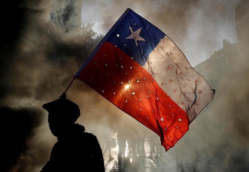 A demonstrator waves a Chile flag riddled with holes during a protest against Chile's government in Santiago, Chile October 31, 2019. REUTERS/Henry Romero TPX IMAGES OF THE DAY - RC1D97375B50