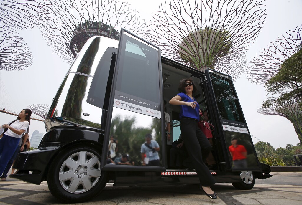 Members of the media disembark from an autonomous self-driving vehicle during a demonstration at Gardens by the Bay in Singapore October 12, 2015.
