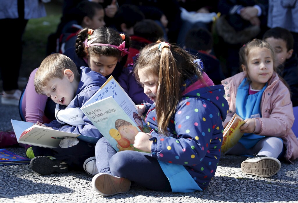 Children read books at Montevideo's Independencia square while participating in the activity "Al Aire Libro" that encourages reading in public spaces, September 4, 2015.