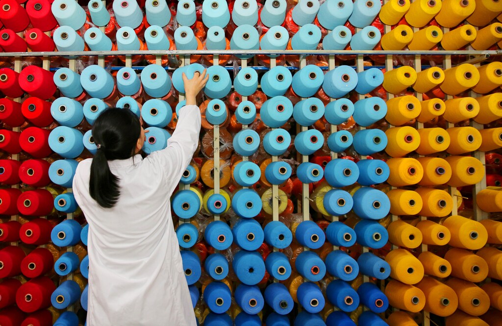 An employee arranges bobbins at a textile plant in Haian county, Jiangsu province, China November 28, 2017. China Daily via REUTERS ATTENTION EDITORS - THIS IMAGE WAS PROVIDED BY A THIRD PARTY. CHINA OUT. TPX IMAGES OF THE DAY - RC1D8928ACA0