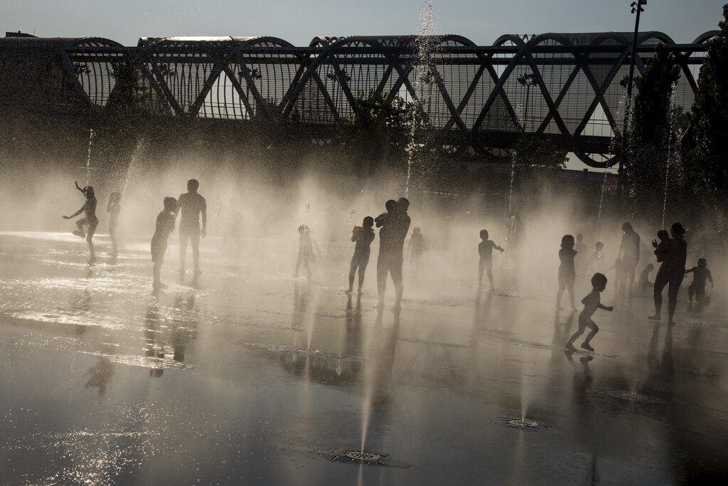 People play while cooling off in a public fountain as temperatures soar to around 40 degrees Celsius (104 degrees Fahrenheit) in central Madrid, Spain, July 13 2015. State meteorological office Aemet said on Wednesday it expected extreme temperatures above 40 degrees Celsius in central provinces for at least another week. REUTERS/Juan Medina TPX IMAGES OF THE DAY - RTX1K90U