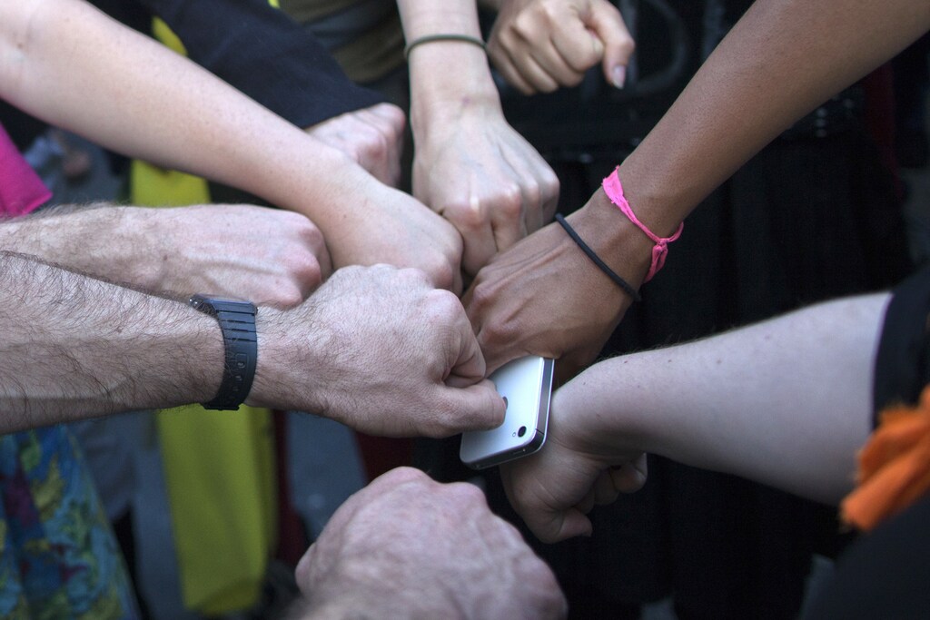 Activist Austin Guest and others join fists in solidarity ahead of a protest march in New York May 1, 2012.