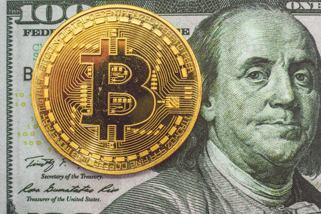a picture of a bitcoin next to an american one hundred dollar bill featuring bill franklin on the front